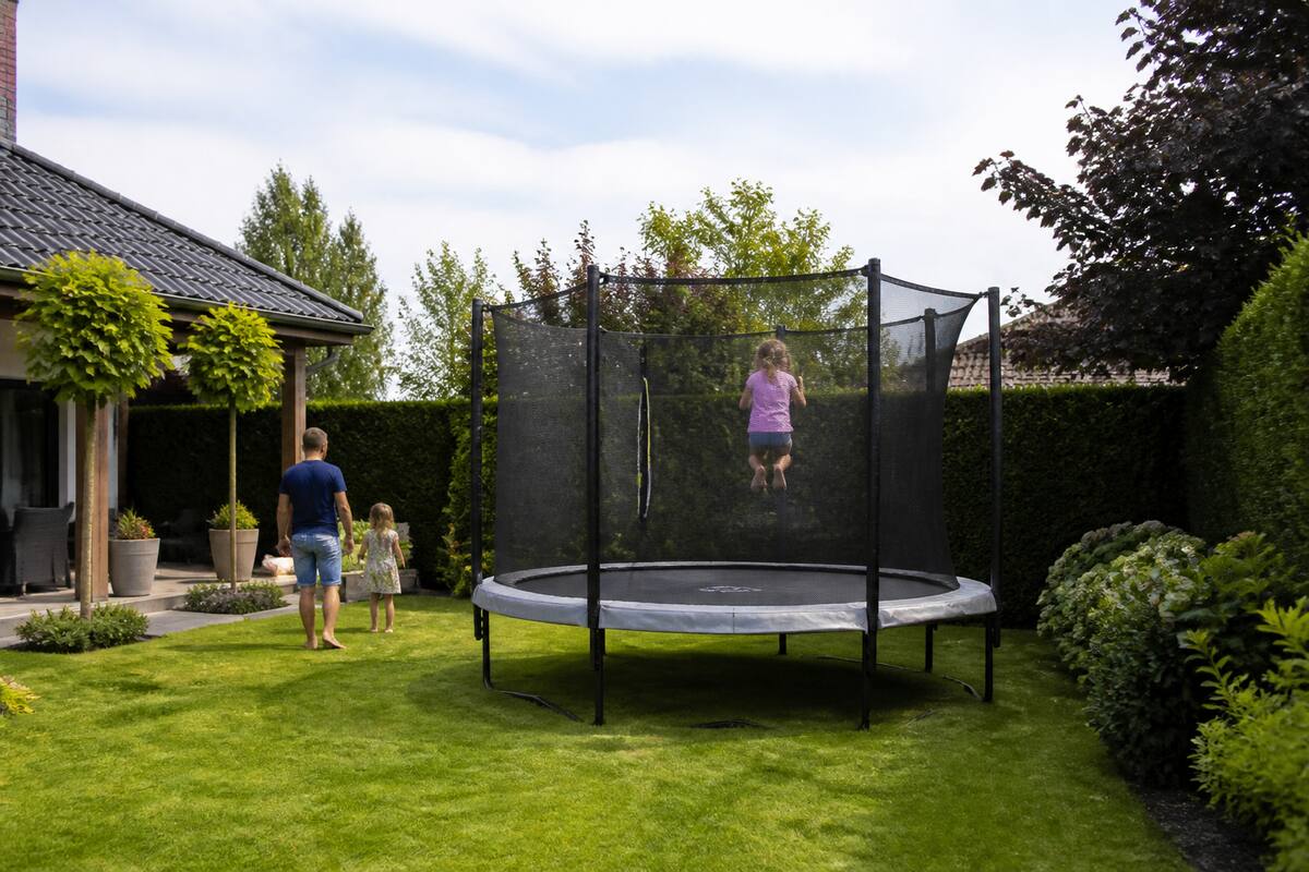 Trampoline met veiligheidsnet in een ruime achtertuin