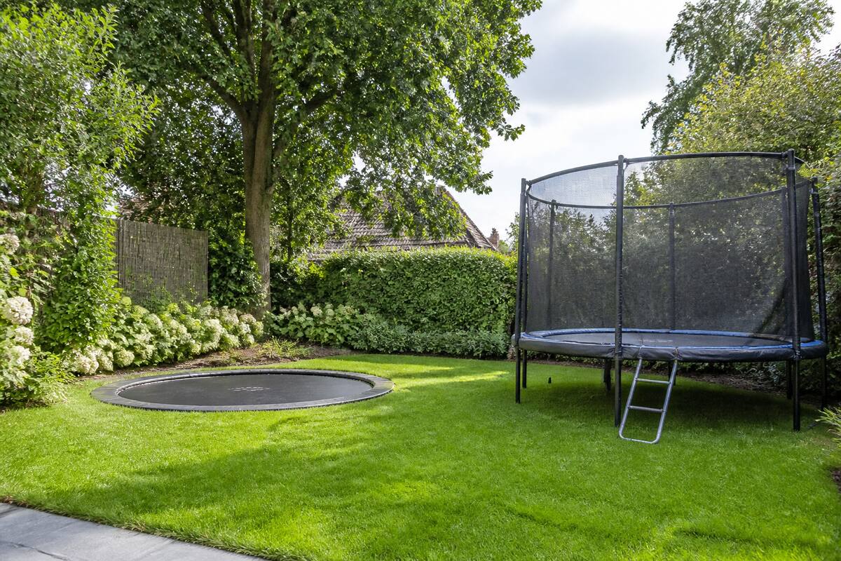 Inground en opbouw trampoline in een moderne tuin